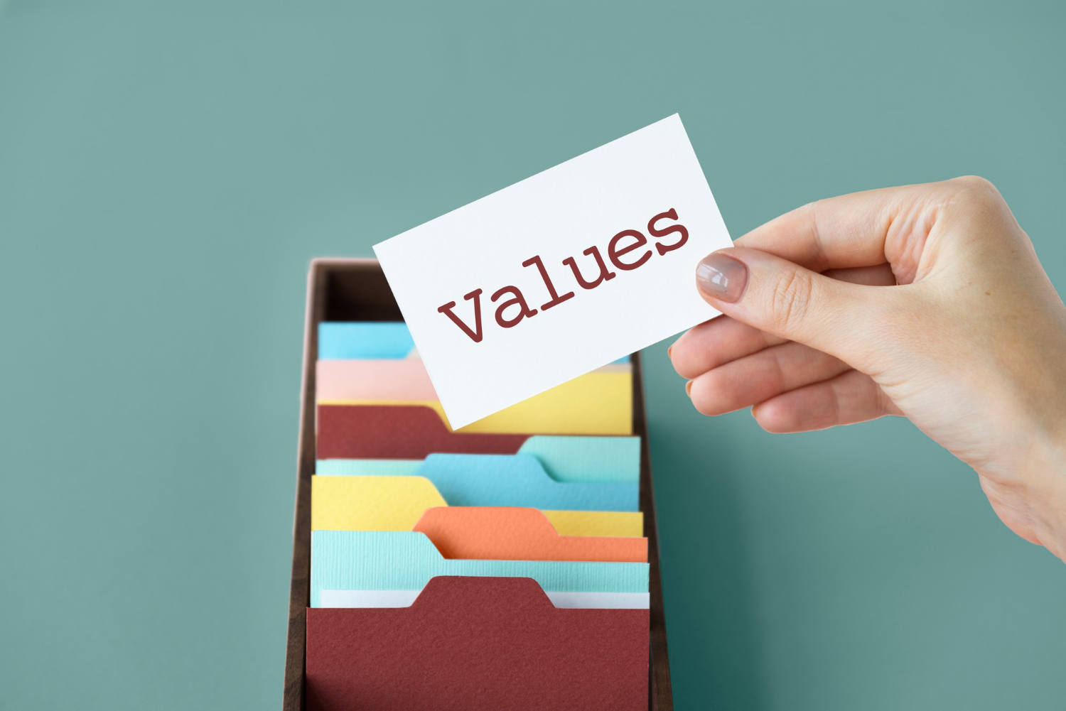 A hand holding a card labeled Values